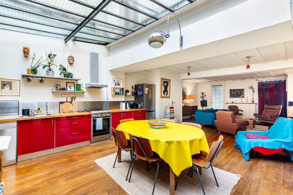 Il dispose d'une cuisine et d'un salon avec une table et des chaises jaunes. dans l'établissement GuestReady - Spacious retreat near Buttes-Chaumont, à Paris