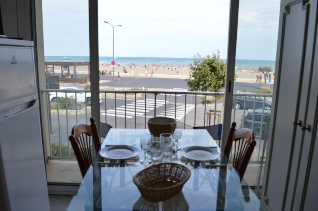 une table et des chaises avec vue sur la plage dans l'établissement NP370-005 Appartement Studio, Narbonne Plage, à Narbonne-Plage