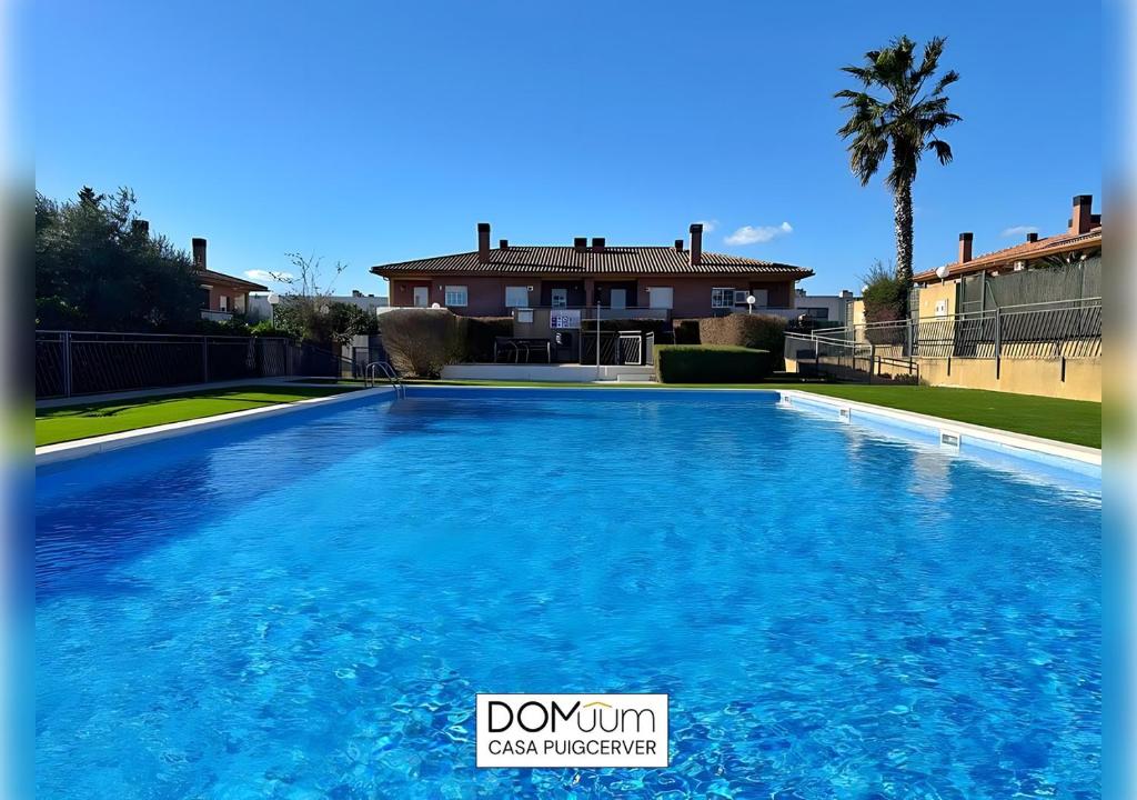 a large blue swimming pool in front of a house at DOMuum Holidays - CASA PUIGCERVER in Cambrils