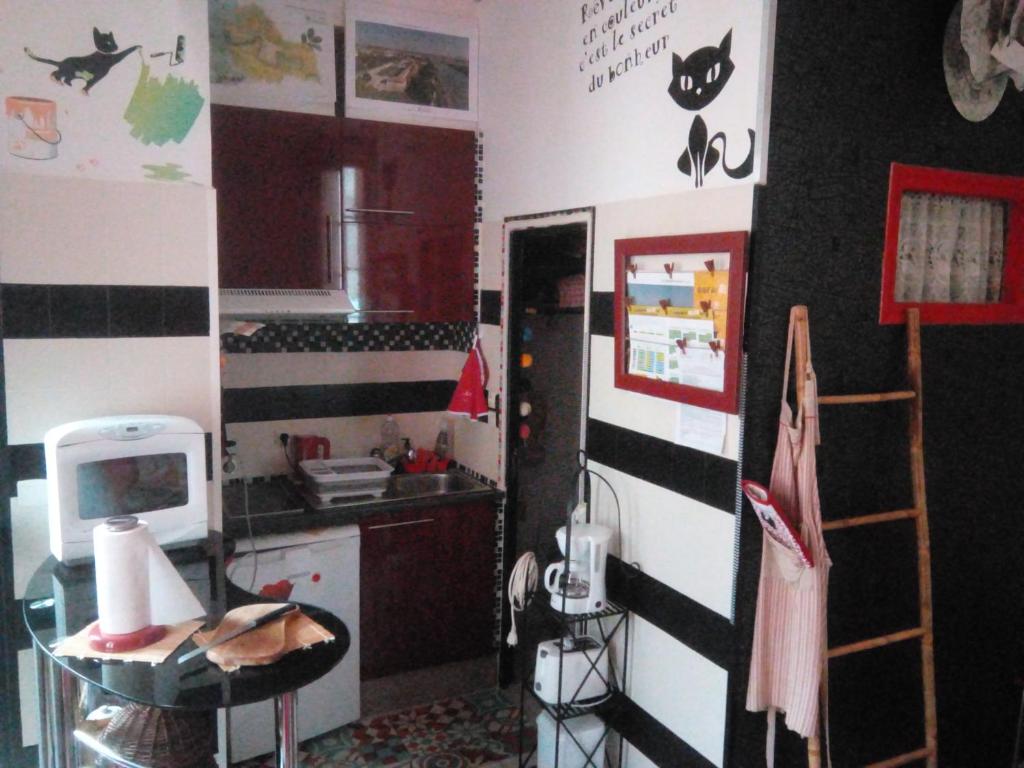 une cuisine avec un mur rayé noir et blanc dans l'établissement STUDIO MEUBLÉ 2étoiles pour 1 personne, à Rochefort