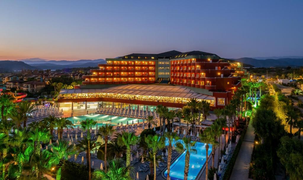 ein Hotel mit einem Pool vor einem Resort in der Unterkunft Delphin Deluxe Resort in Okurcalar
