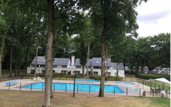 een zwembad voor een gebouw met bomen bij Vakantiebungalow BERK 1 in Aan de Wolfsberg