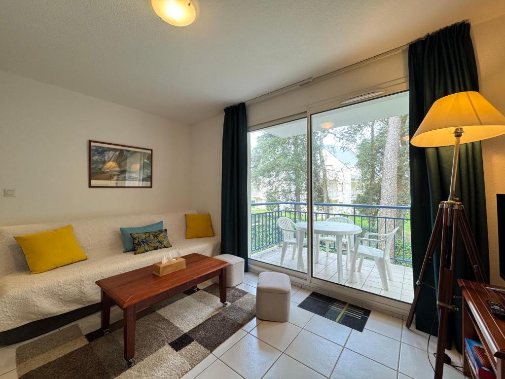 un salon avec un canapé et une table dans l'établissement Azur Marin - Wifi, Parking, Piscine, Mer à 2min, à Pornichet