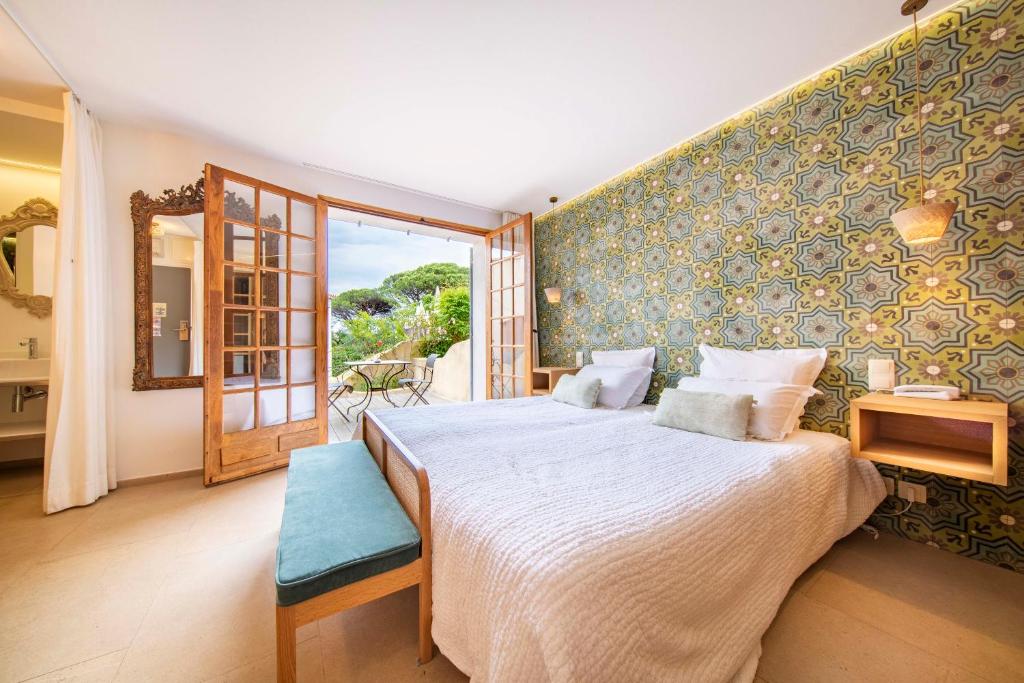 a bedroom with a large bed and a large window at Les Capucines Saint Tropez in Saint-Tropez
