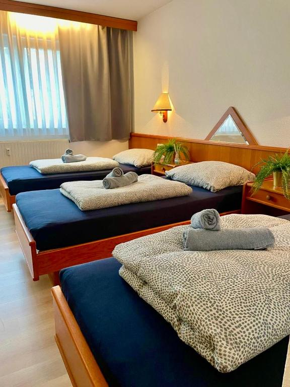 three beds in a hotel room with towels on them at Schwanstetten bei Nürnberg, gemütliches Apartment mit Küche Bad TV in Schwanstetten