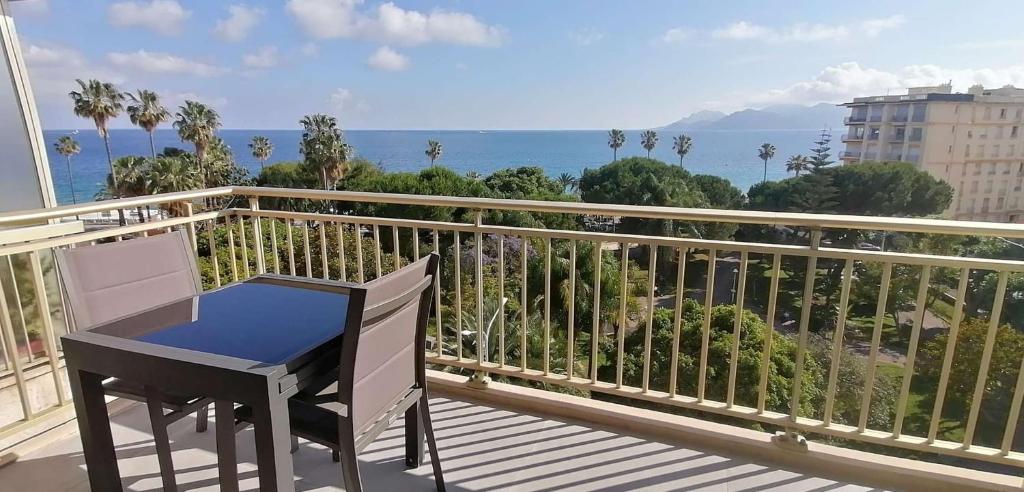 un balcon avec une table et une vue sur l'océan dans l'établissement Cannes centre-ville - Face mer 3 pièces avec terrasse, à Cannes