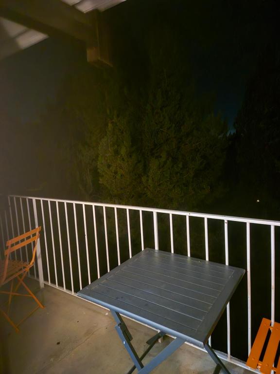 une table de pique-nique sur un porche avec une clôture dans l'établissement Appartement font-romeu, à Font-Romeu-Odeillo-Via