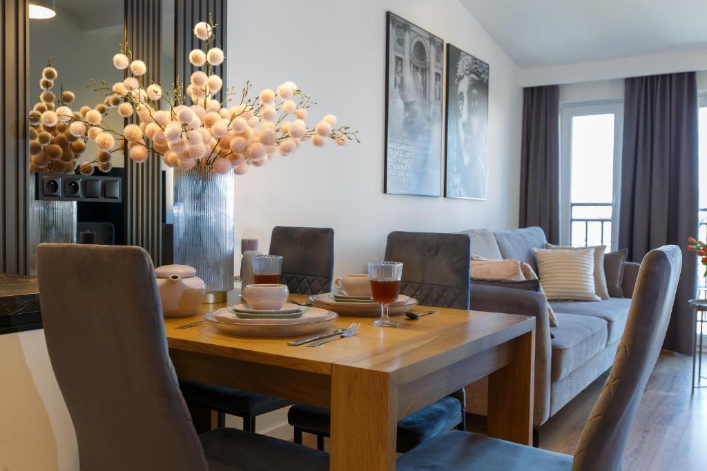 a living room with a wooden table and a couch at Apartamenty PREMIUM 56 obok Rynku Centrum, Parking - GARAŻ PODZIEMNY, wysoki standard, spokojna i cicha okolica, Parking - UNDERGROUND GARAGE, high standard, peaceful and quiet area in Kielce