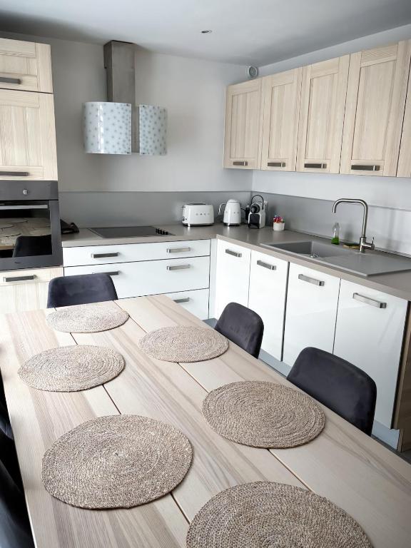 une cuisine avec une table, 4 chaises et un comptoir dans l'établissement Lescapade à Colmar, à Colmar