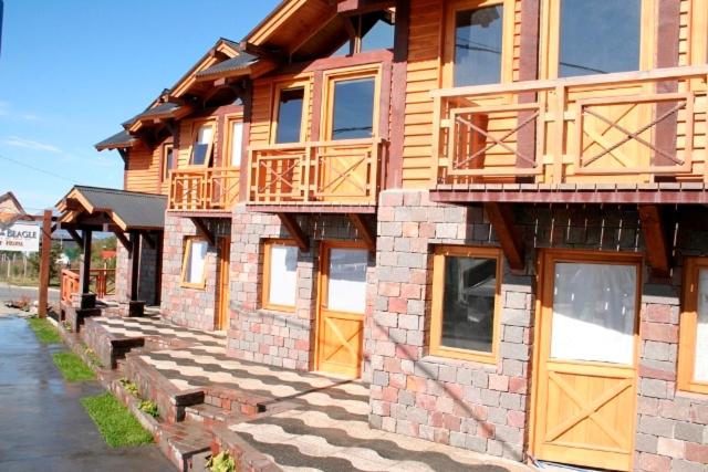 a large building with wooden doors and windows at Aires del Beagle Apartment in Ushuaia