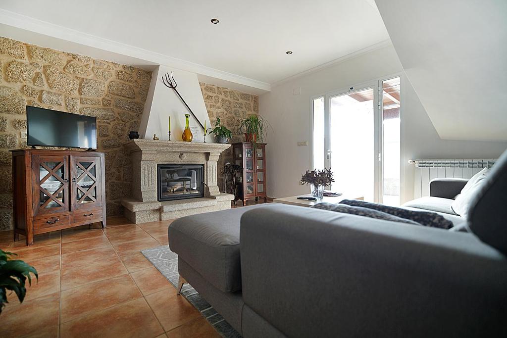 Una sala de estar con una cama y una chimenea. en GALIHOST - Apartamento entre viñedos, en Cambados