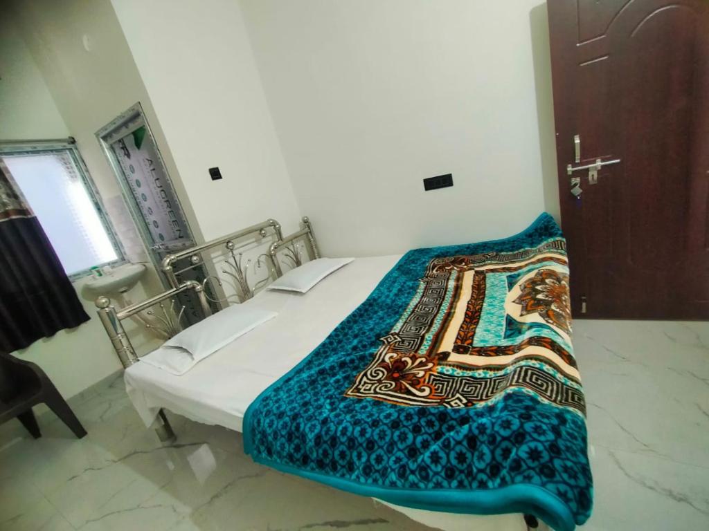 a bedroom with a bed with a blanket on it at Shivay Guest house in Jasidih