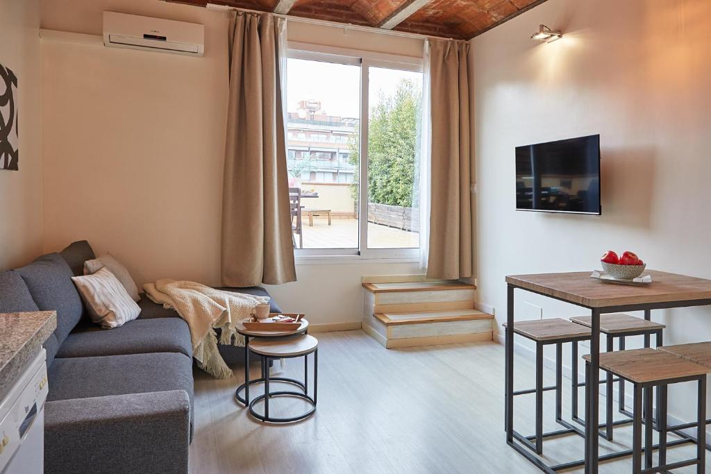a living room with a couch and a tv at BBarcelona Sagrada Familia Flats in Barcelona