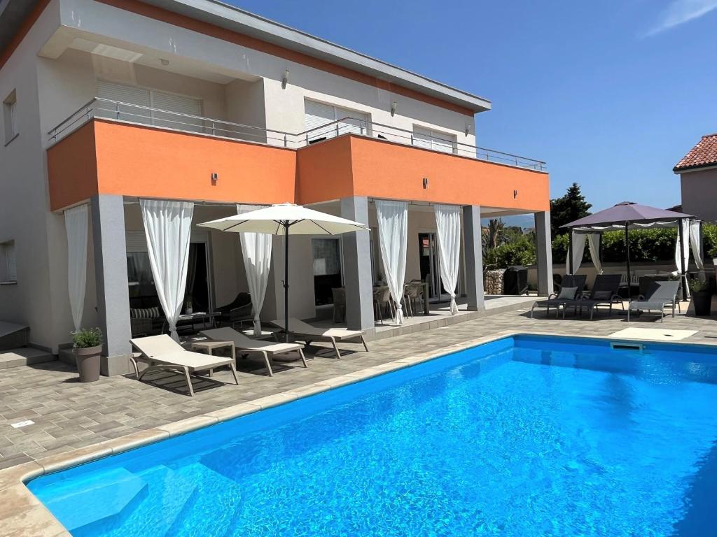 a villa with a swimming pool in front of a building at Villa Summer Escape In Barbat Mit Garten Und Aussicht in Barbat na Rabu