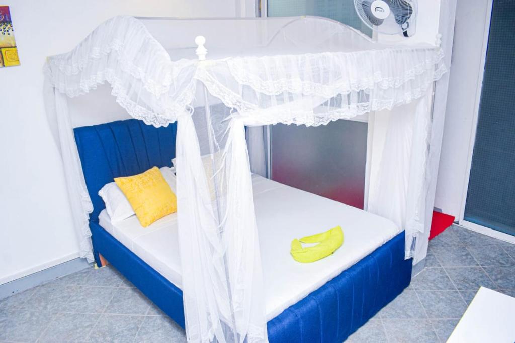 1 dormitorio con cama con dosel y 2 bananas en Blessing homes, en Mombasa