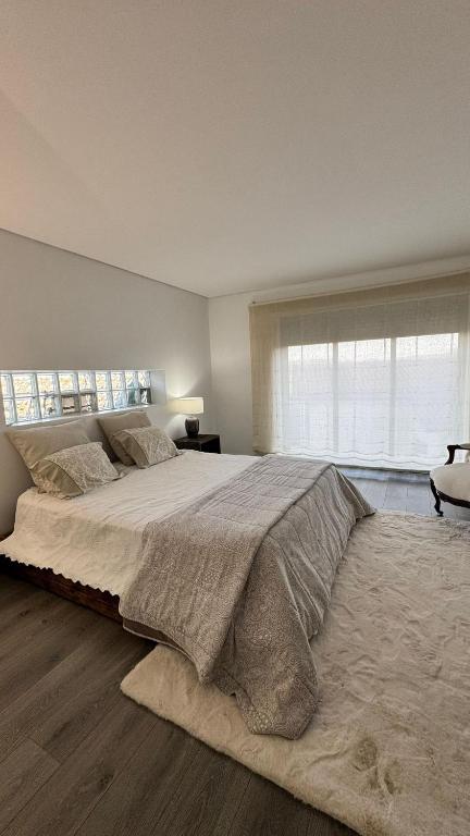 une chambre avec un grand lit avec une grande fenêtre dans l'établissement Réveillon 2026 CASA LOS PADEL - Vitorino dos Piães, à Navio