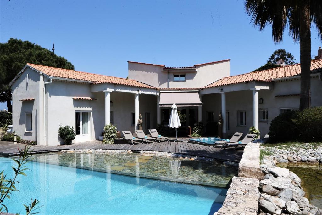 une maison avec une piscine devant dans l'établissement Villa Liza du Cap d'Antibes, à Antibes