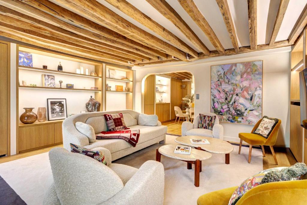 un salon avec un canapé et des chaises dans l'établissement Elegance et Confort au Coeur de Paris, à Paris