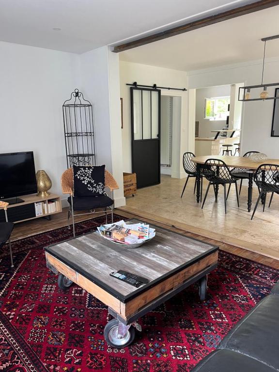 a living room with a table on a rug at Côté rivière in Venarey-les-Laumes