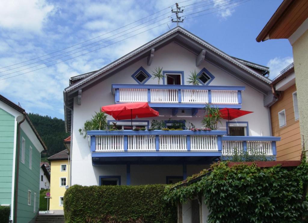 Casa con balcón con sombrillas rojas en Ferienwohnung Örtl In Obernzell, en Obernzell