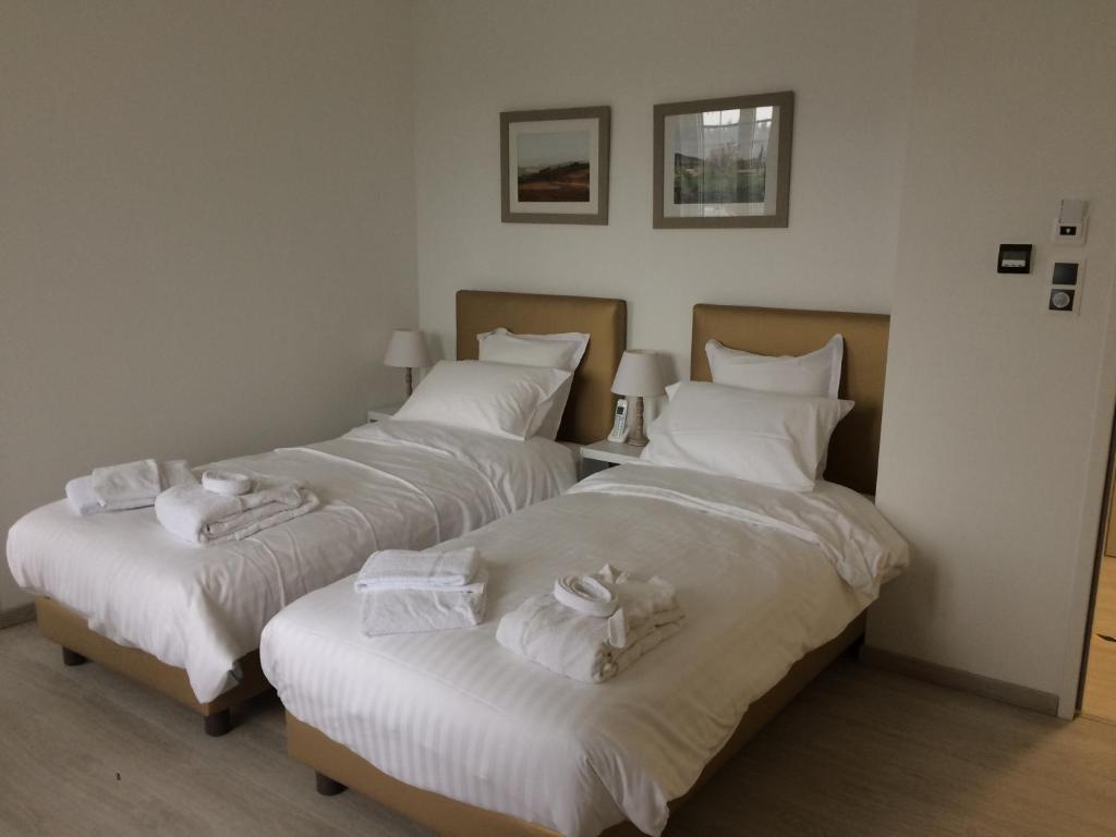- 2 lits dans une chambre avec des draps blancs et des serviettes dans l'établissement Domaine de Mandrin, à Madranges