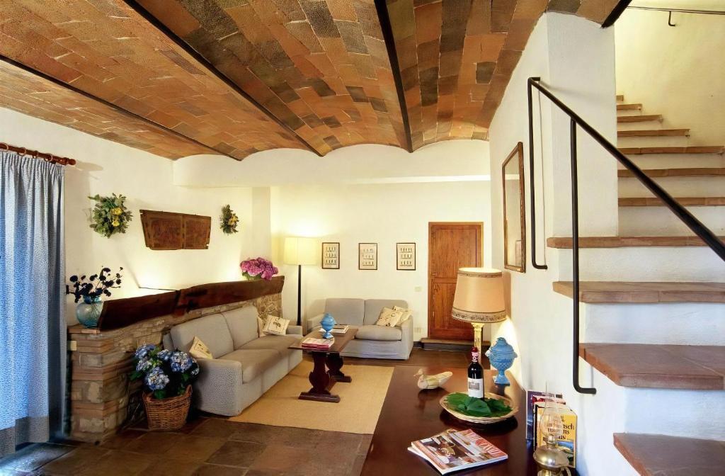 un salon avec un canapé et un escalier dans l'établissement Appartamento Blu, à San Donato in Poggio