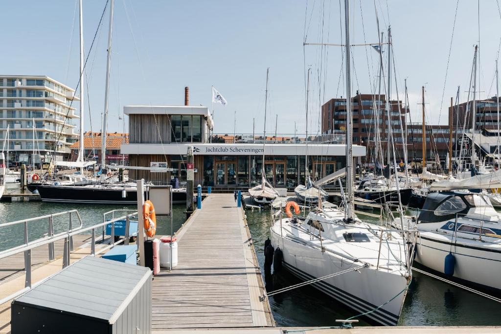 een dok met boten aangemeerd in een jachthaven met gebouwen bij BizStay Harbour III Scheveningen Apartments in Scheveningen
