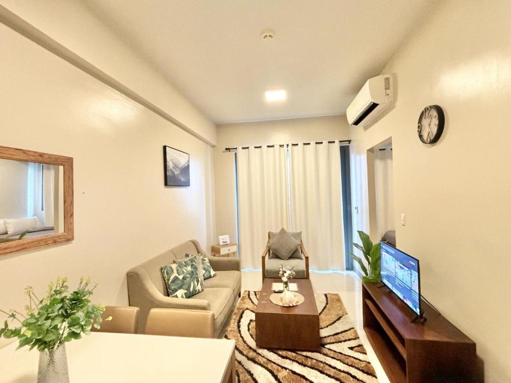 a living room with a couch and a tv at Family-Friendly Condo Unit in Lapu Lapu City