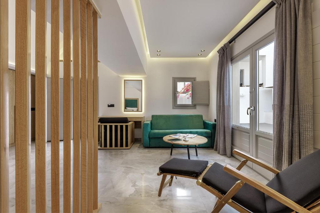 a living room with a green couch and a table at Kalisti Hotel & Suites in Fira