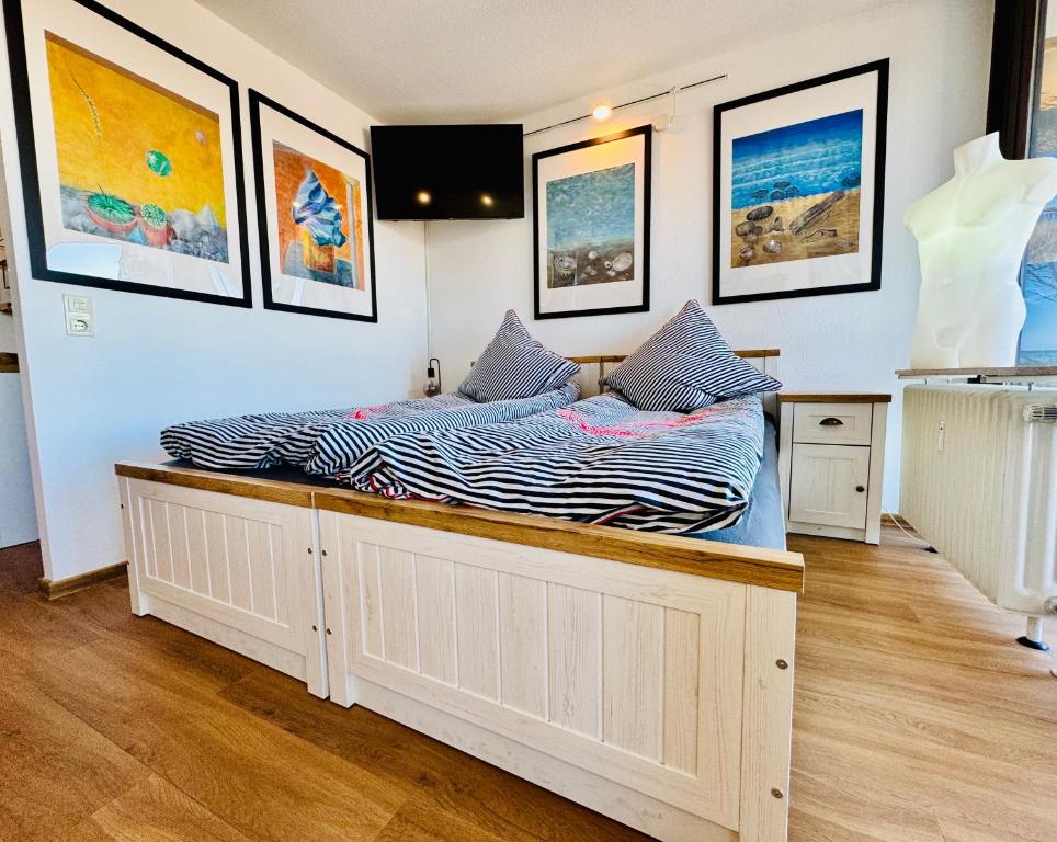 a bed in a room with pictures on the wall at Lütte Wulke 8, wo Träume Weite finden in Wunstorf
