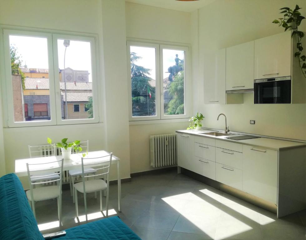 a kitchen with white cabinets and a table and chairs at Casa Clorofilla in Magenta