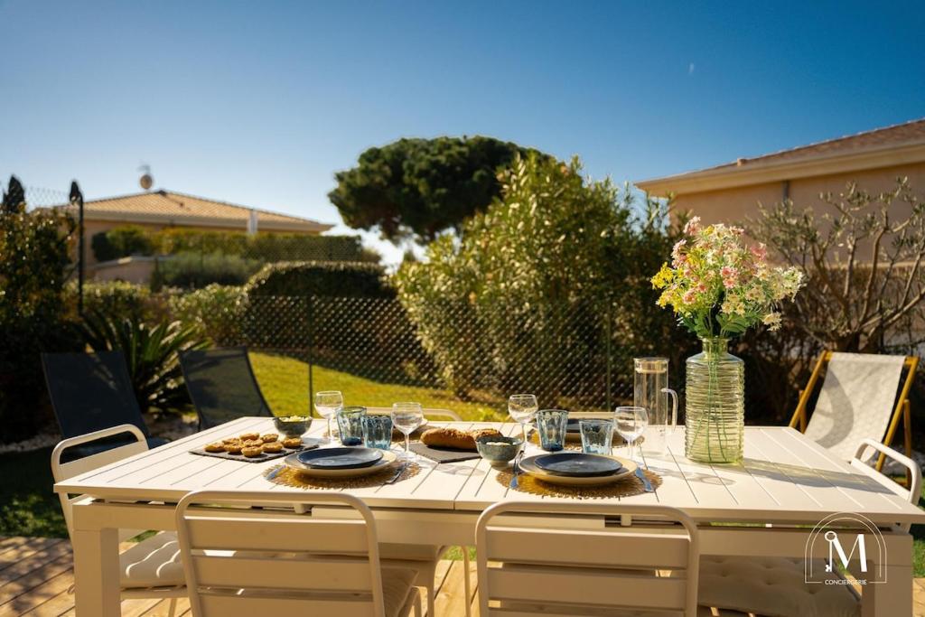 une table blanche avec des assiettes de nourriture dans l'établissement Appartement cosy dans résidence avec piscine, à Sanary-sur-Mer