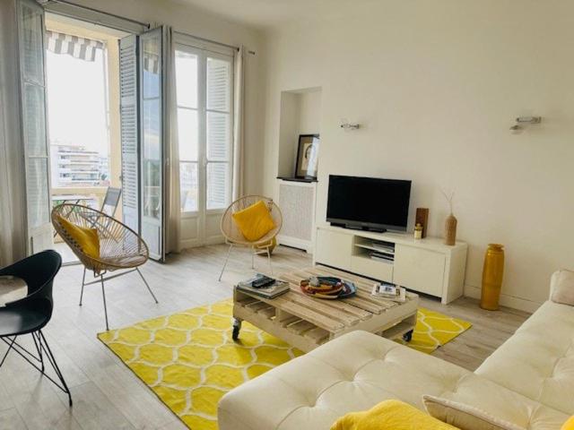 un salon avec un canapé, des chaises et une télévision dans l'établissement Appartement Roi Albert, à Cannes