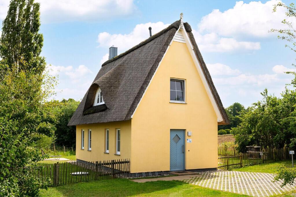 a yellow house with a gambrel roof at Reethaus Schwan Mit Großem Grundstück in Gramkow