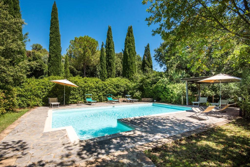 a swimming pool in a yard with umbrellas at Melograno Apartment Podere Giardino in Montalcino