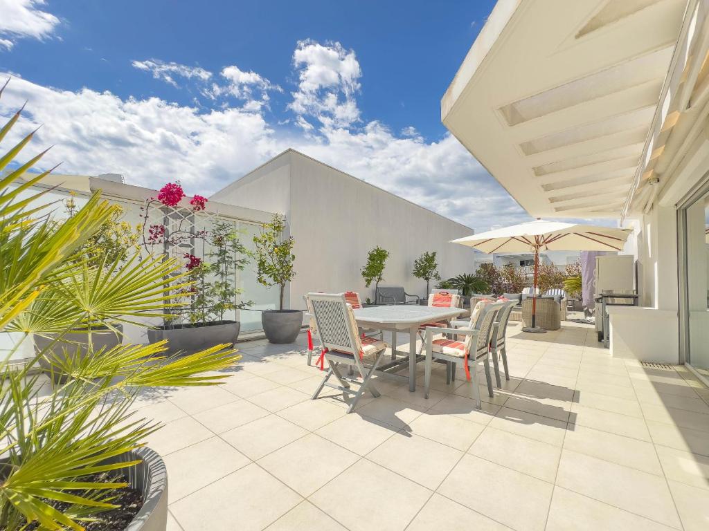 un patio avec une table, des chaises et des plantes dans l'établissement Le Rooftop by Winsome Destination, à Cannes
