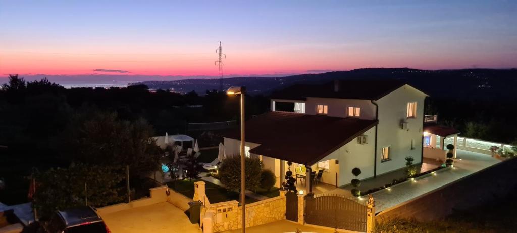 a house with a sunset in the background at Apartment Sanja in Kaštel