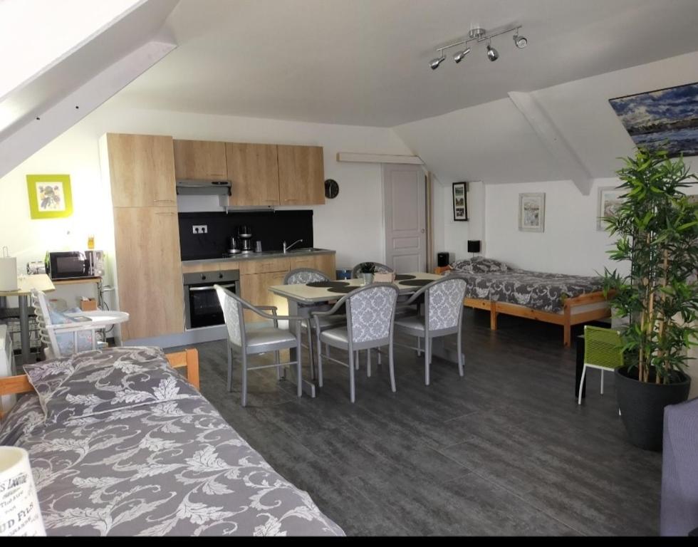 a living room with a table and chairs and a kitchen at Le gîte d'Isa in Montfarville
