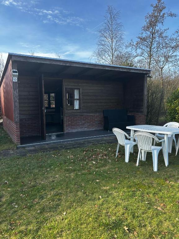 a picnic table and chairs in front of a building at Schuilstal in Elim