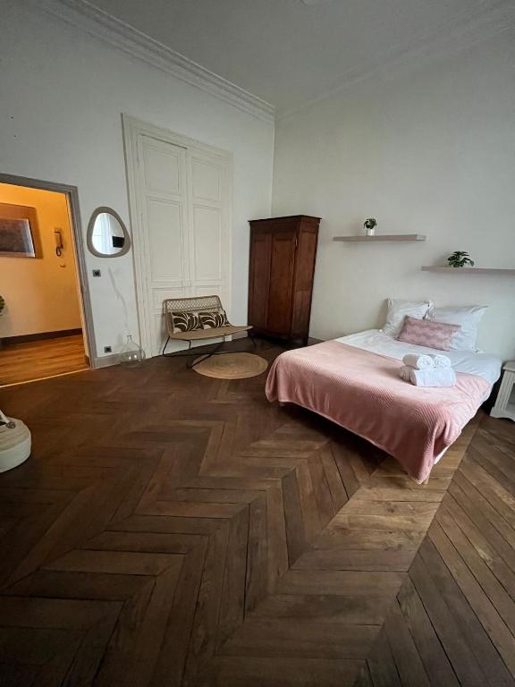 une chambre avec un lit et un parquet dans l'établissement Appartment Doutre Terrasse- 2ch, à Angers