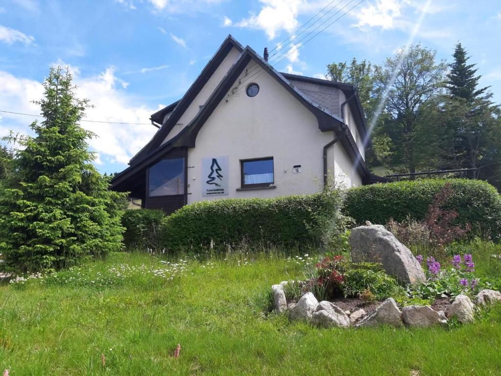 a white house with a black roof at Fewo Am Skihang Eg in Eibenstock