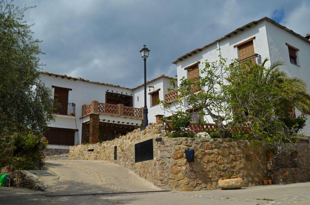a large white house with a stone wall at Casa Número 7 in Válor