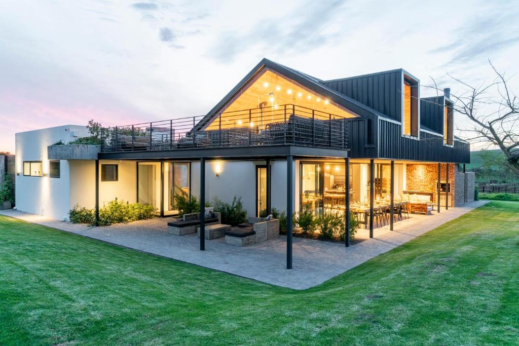 een huis met een grote tuin met gras bij EersteBosch Cottages in Stellenbosch