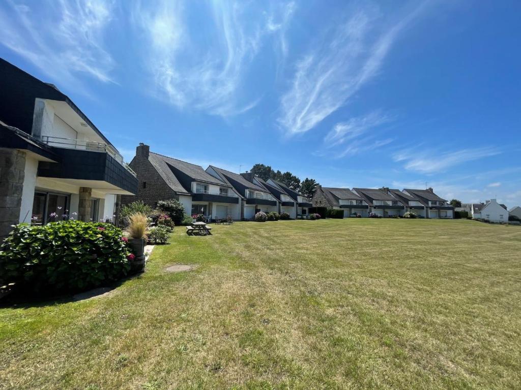 eine Reihe von Häusern in einem Hof mit einem Grasfeld in der Unterkunft Fetan Stirec - Appt vue mer in Locmariaquer