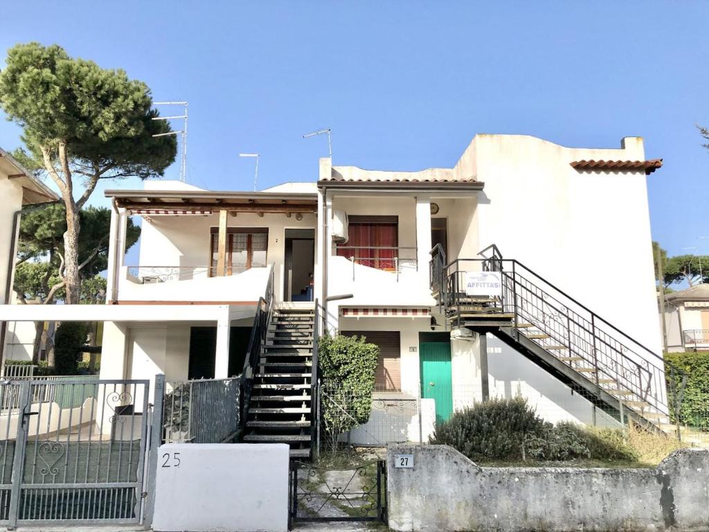 a white house with stairs in front of it at Lidia in Rosolina