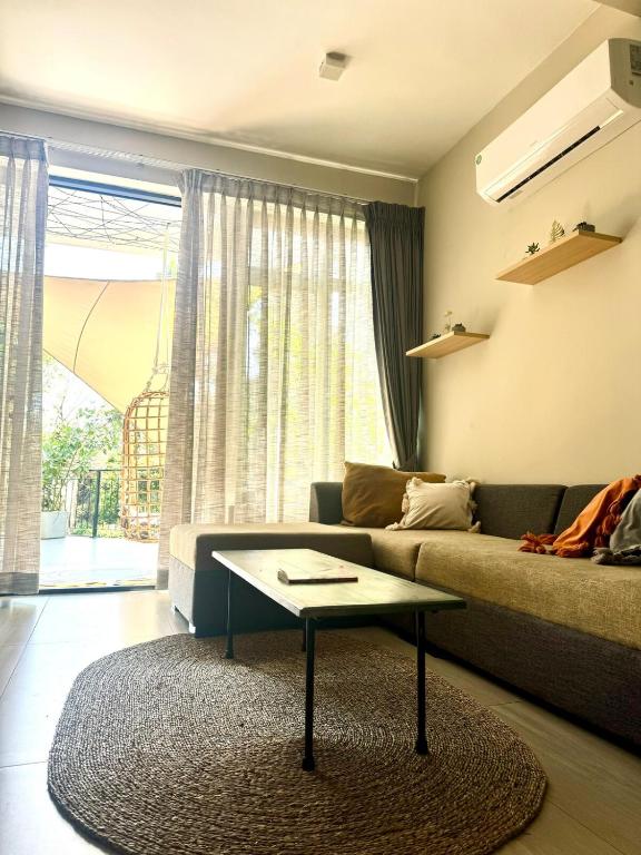 a living room with a couch and a coffee table at Unit One by Hideout Lounge in Kandy