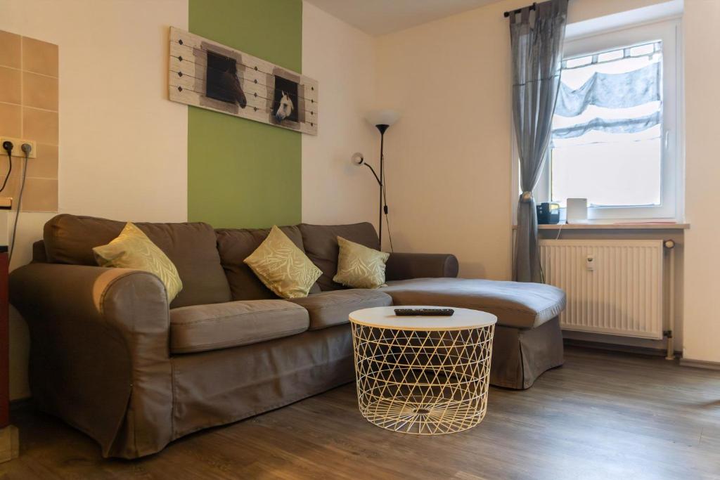a living room with a brown couch and a table at Ferienwohnung Mit Zwei Schlafzimmern Und Balkon in Weißenstadt