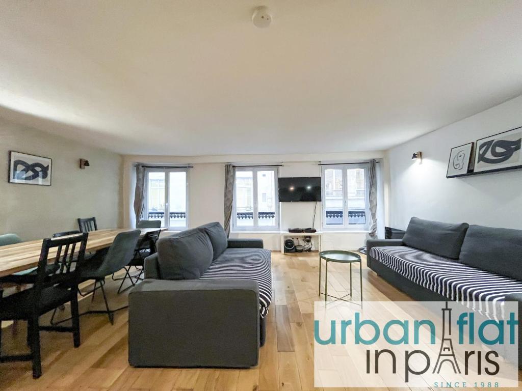 un salon avec un canapé et une table dans l'établissement Urban Flat 89 - Charming Central Flat, à Paris