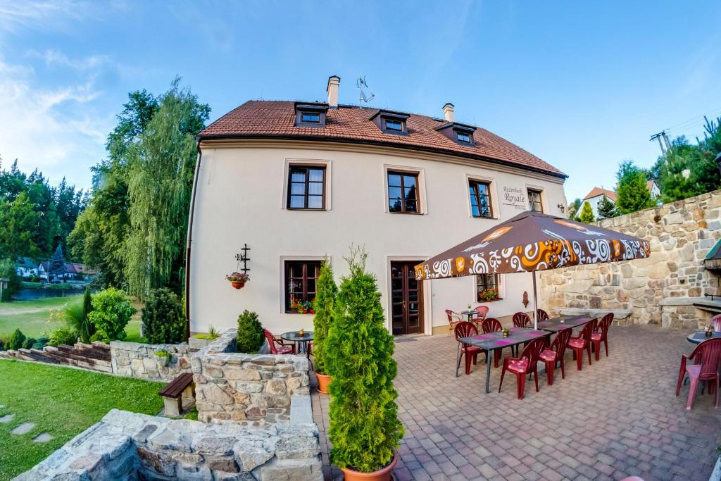 uma casa com uma mesa e cadeiras em frente em Rožmberk Royale Pension em Rožmberk nad Vltavou