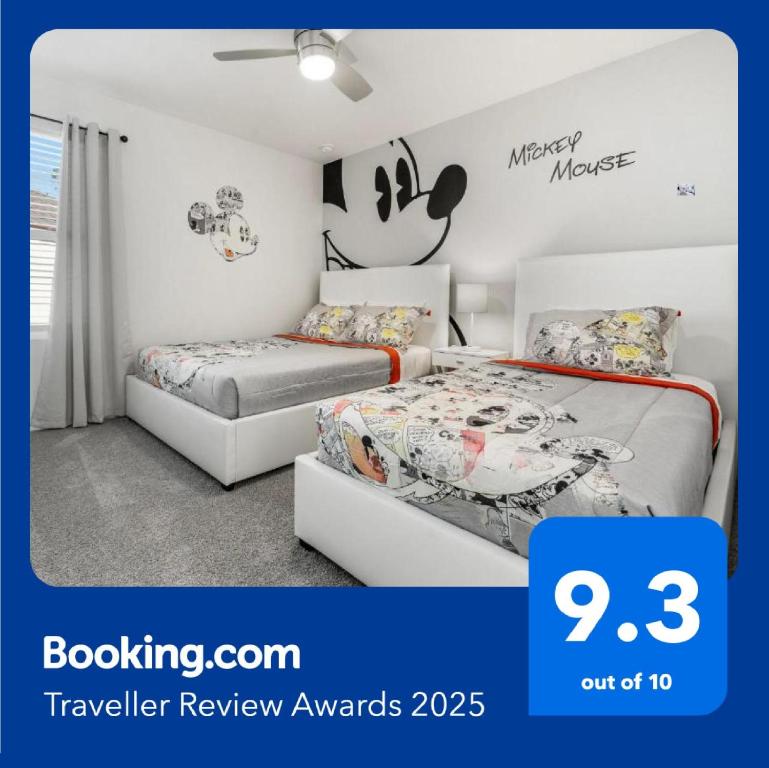 1 dormitorio con 2 camas y una pared con un mural de ratón Mickey en Amazing Villas 20 minutes away from Disney!, en Kissimmee
